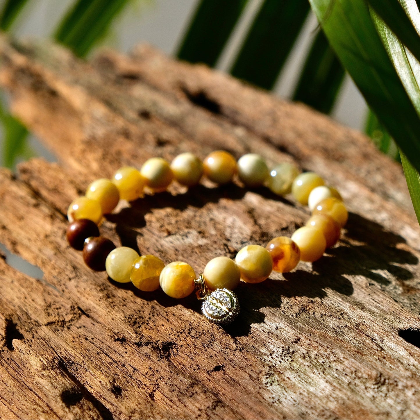 Beaded bracelet on a wooden surface with leaves in the background