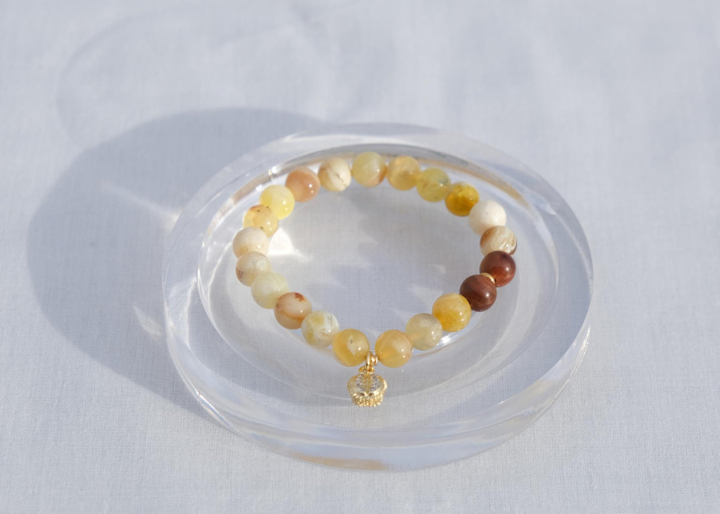 Multicolored beaded bracelet on a clear stand against a white background