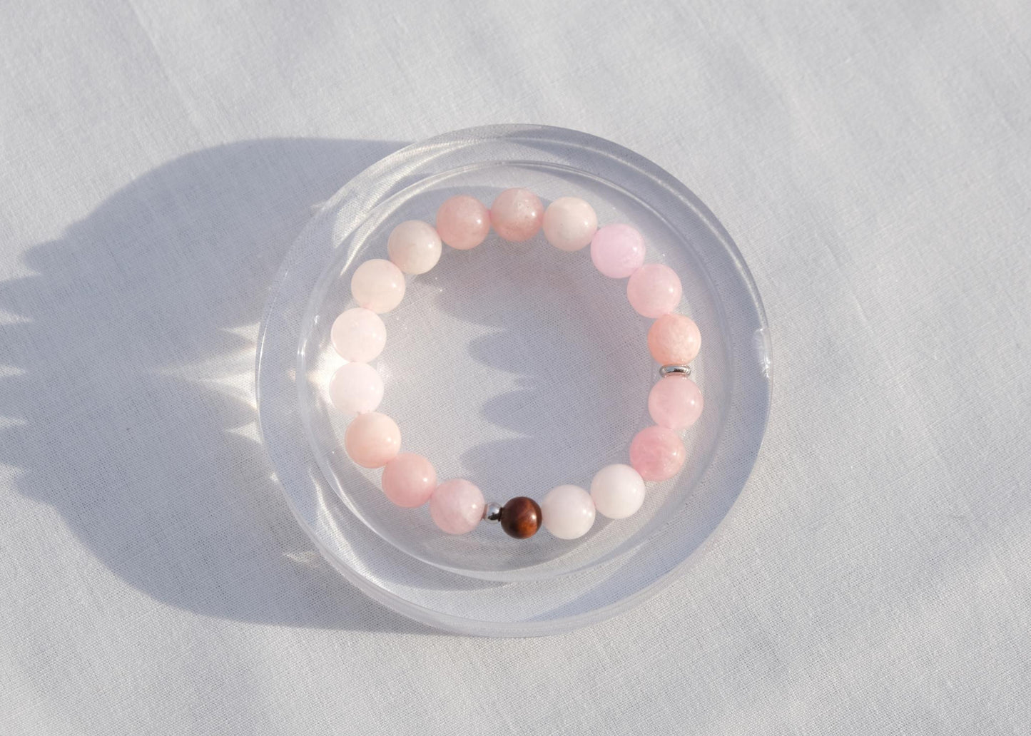 Beaded bracelet with pink and brown beads on a white surface
