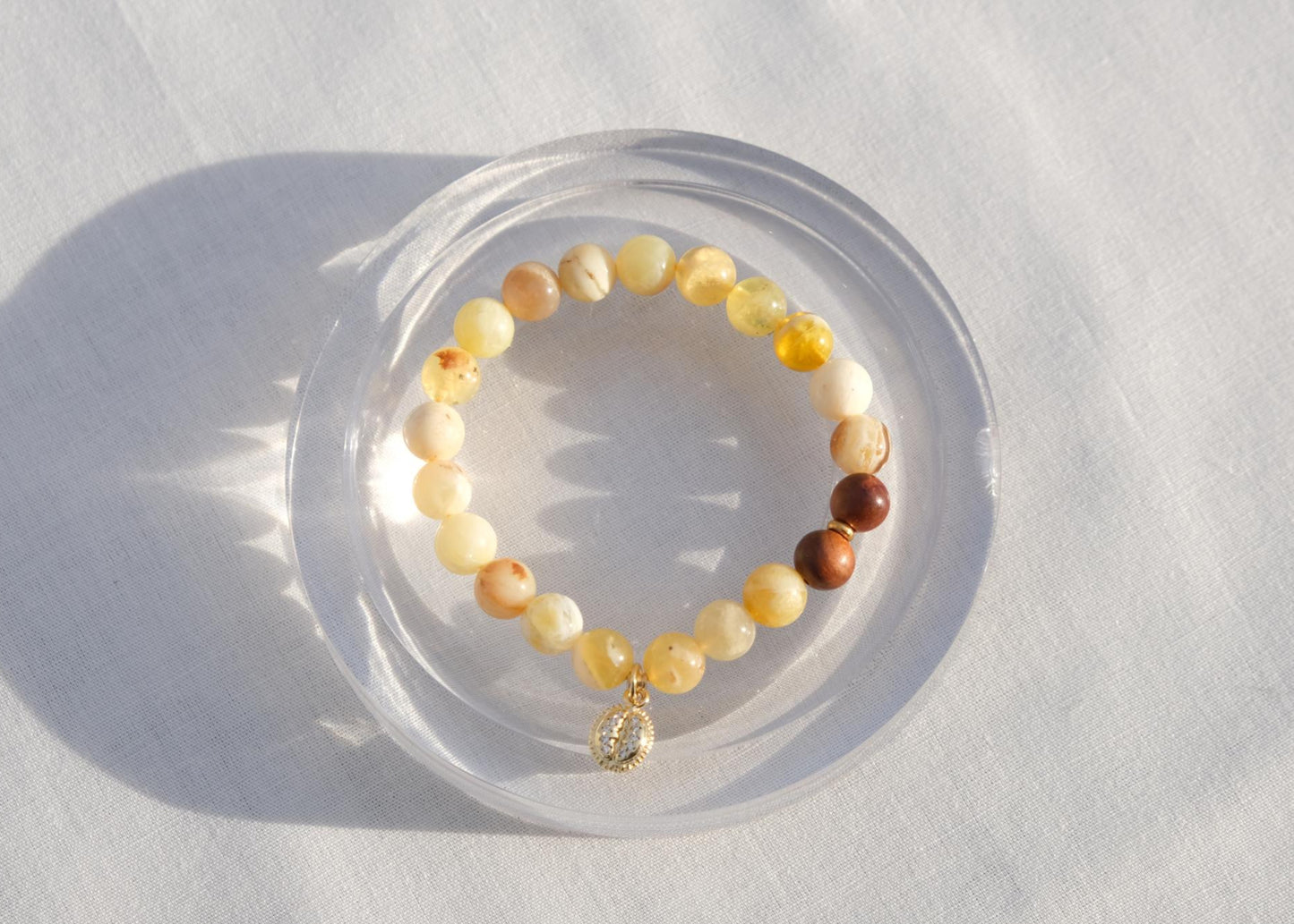 Beaded bracelet on a white surface with soft shadows