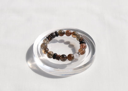 Bracelet with multicolored beads on a clear stand against a white background