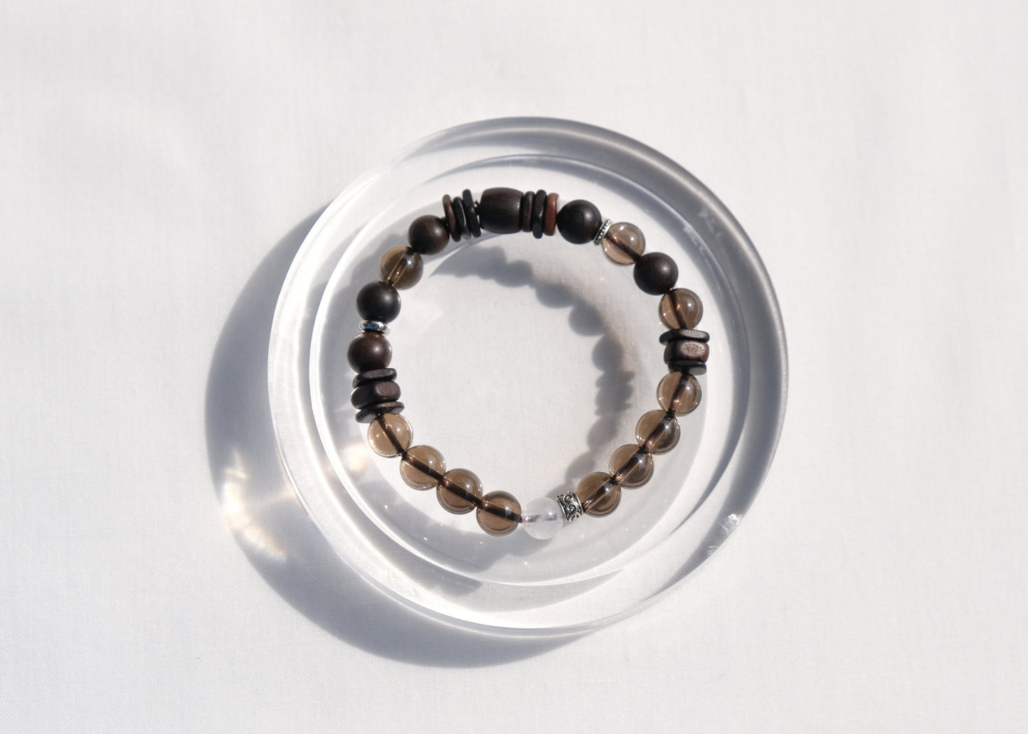 Beaded bracelet on a clear circular stand against a white background