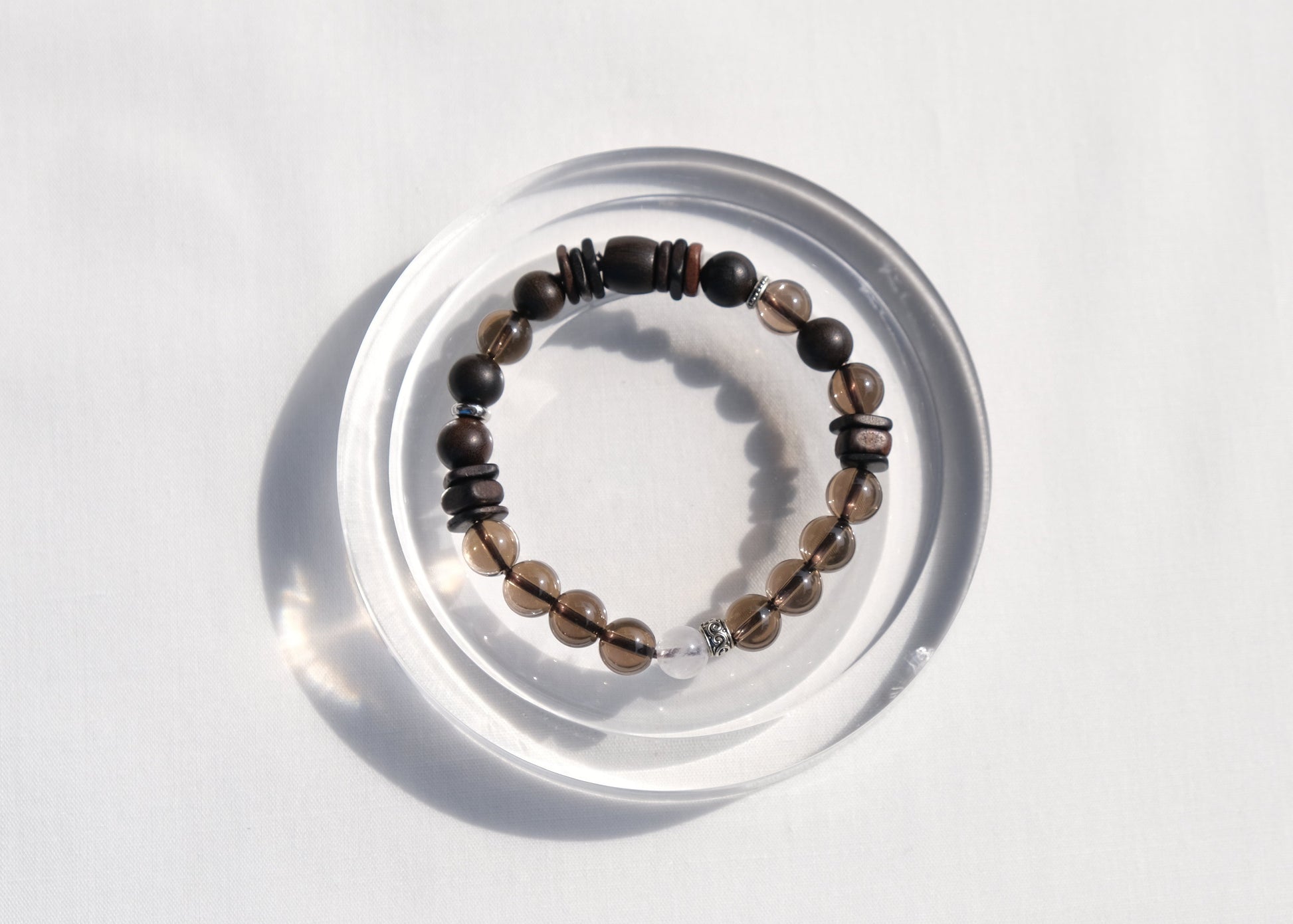 Beaded bracelet on a clear circular stand against a white background