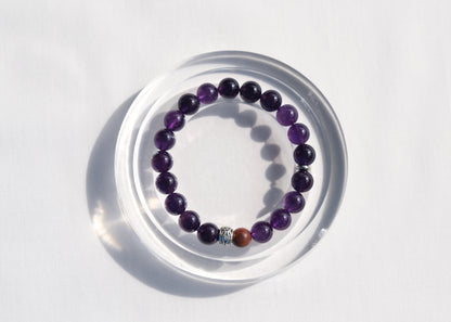 Amethyst bracelet on a clear stand with a white background