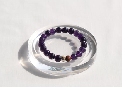 Amethyst beaded bracelet on a clear stand with a white background