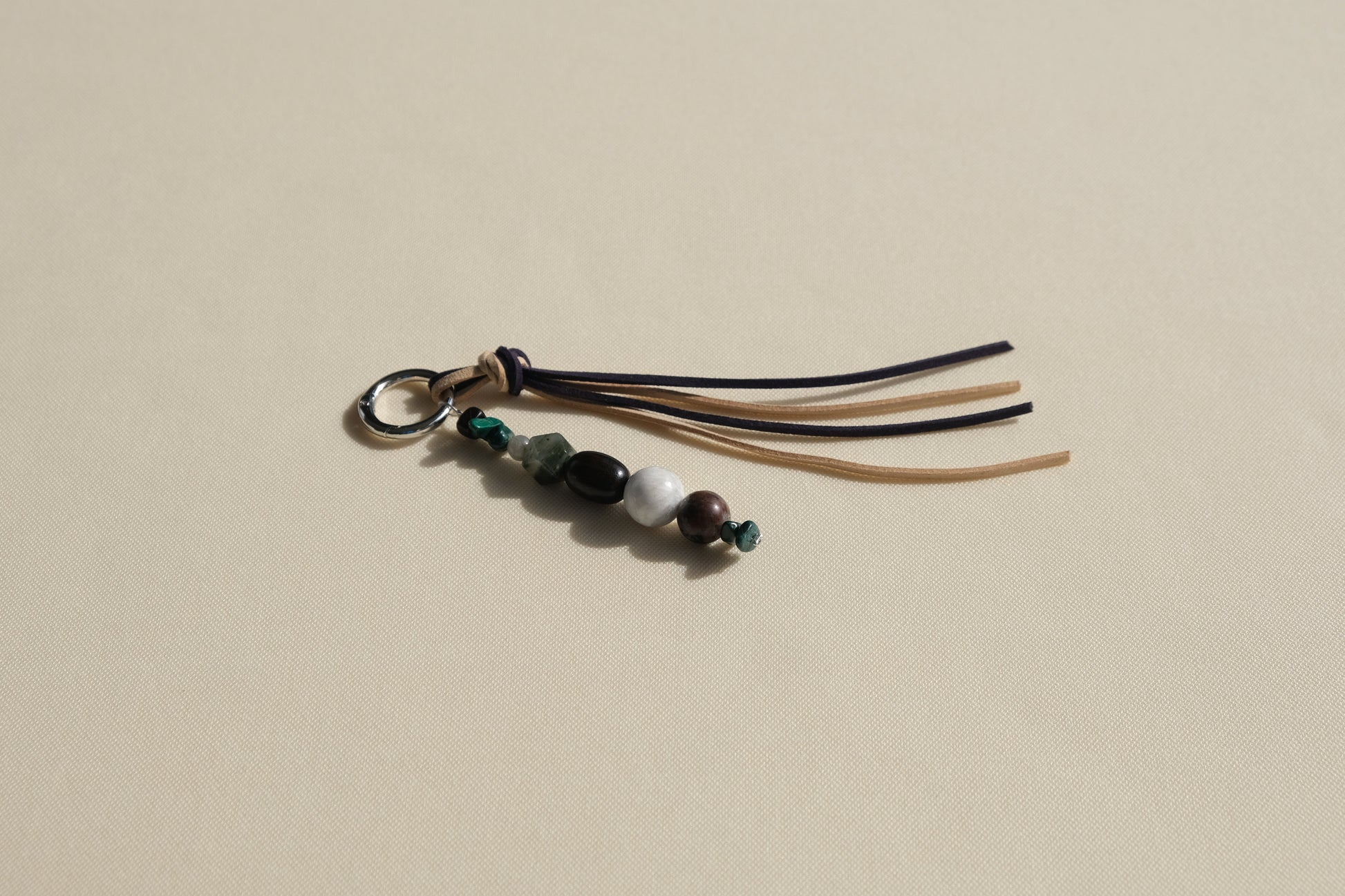 Beaded keychain with tassels on a beige background