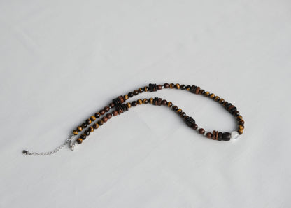 Necklace with tiger eye beads on a light gray background