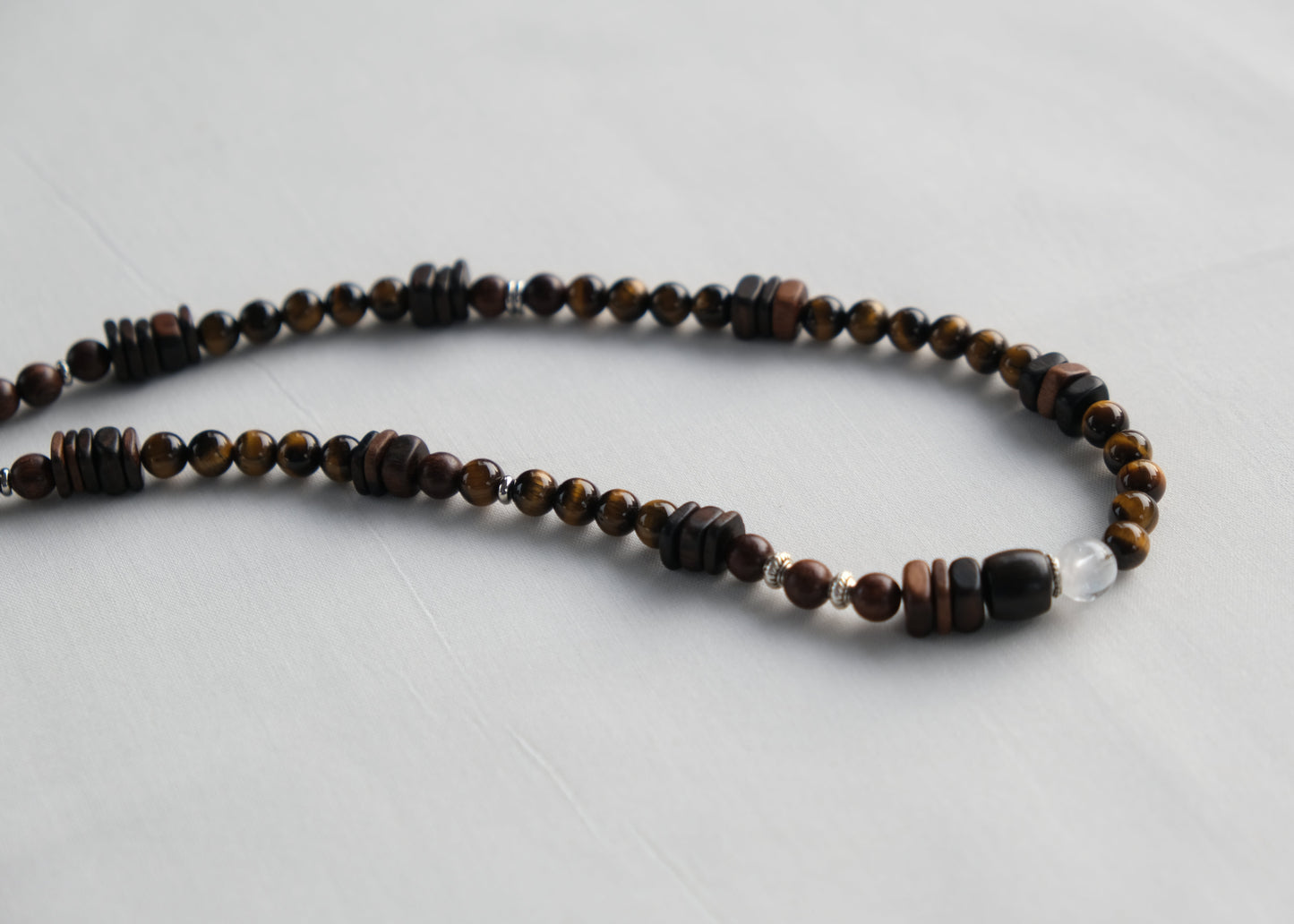 Necklace with brown and black beads on a light gray background