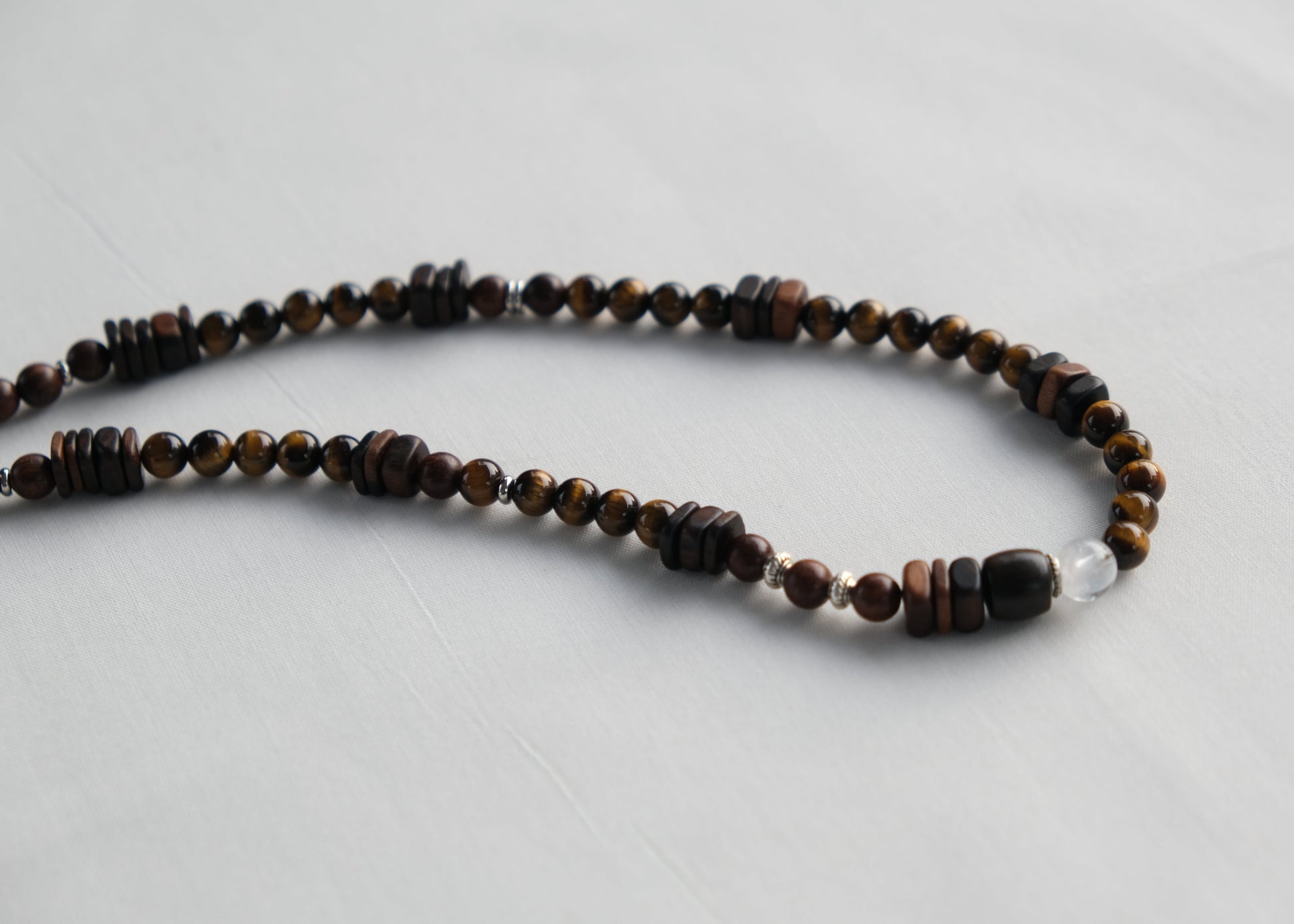 Necklace with brown and black beads on a light gray background
