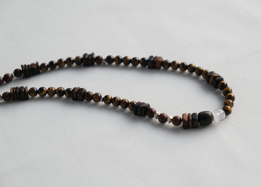 Necklace with brown and black beads on a light gray background