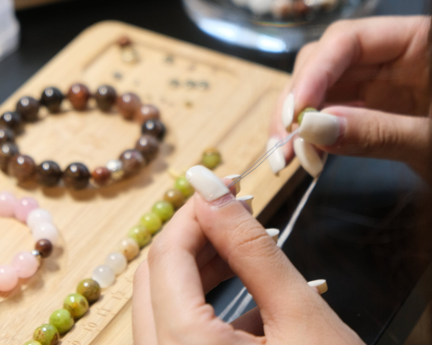 Person working with beads on a wooden board
