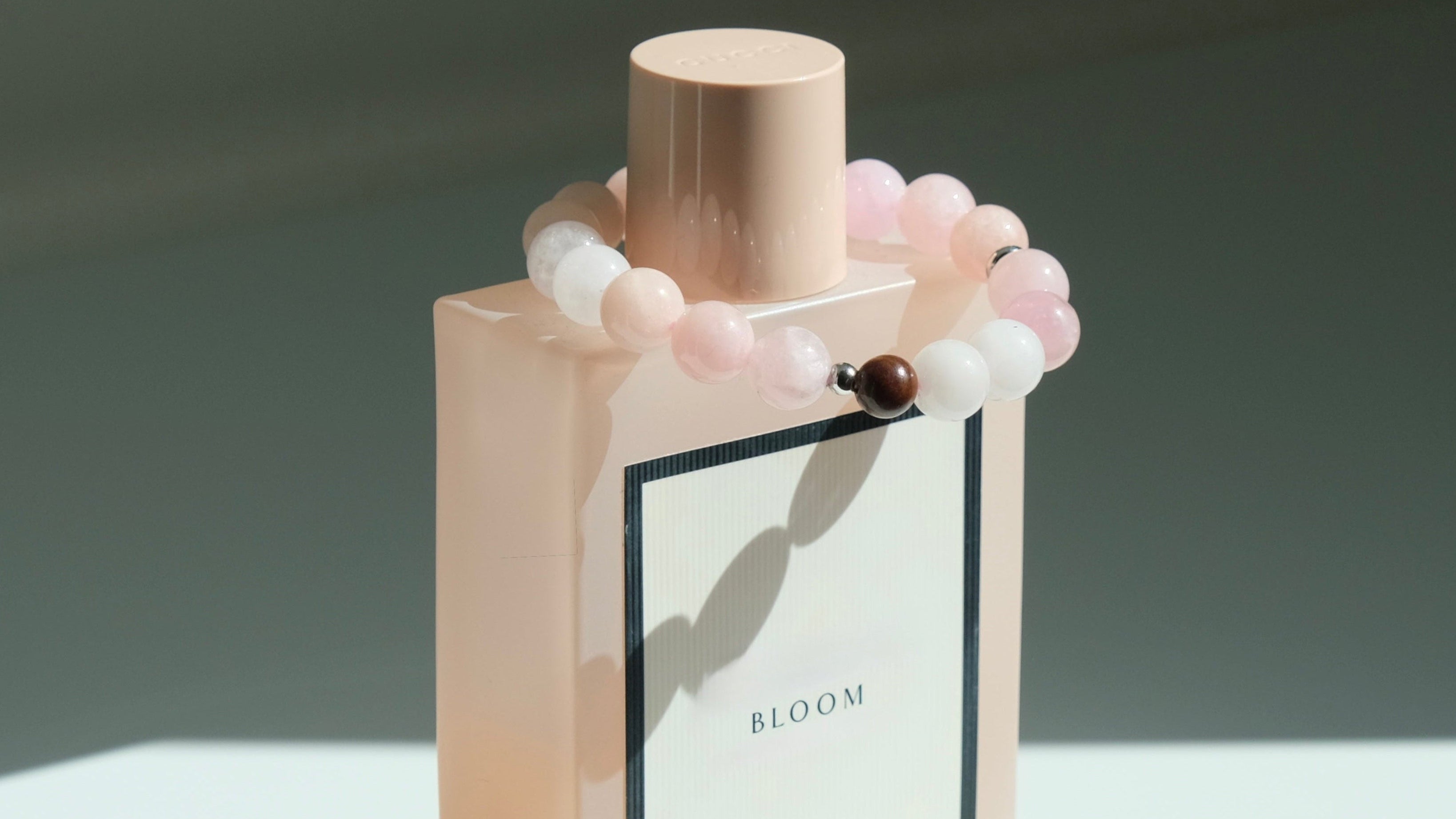 Perfume bottle with decorative beads on a white surface