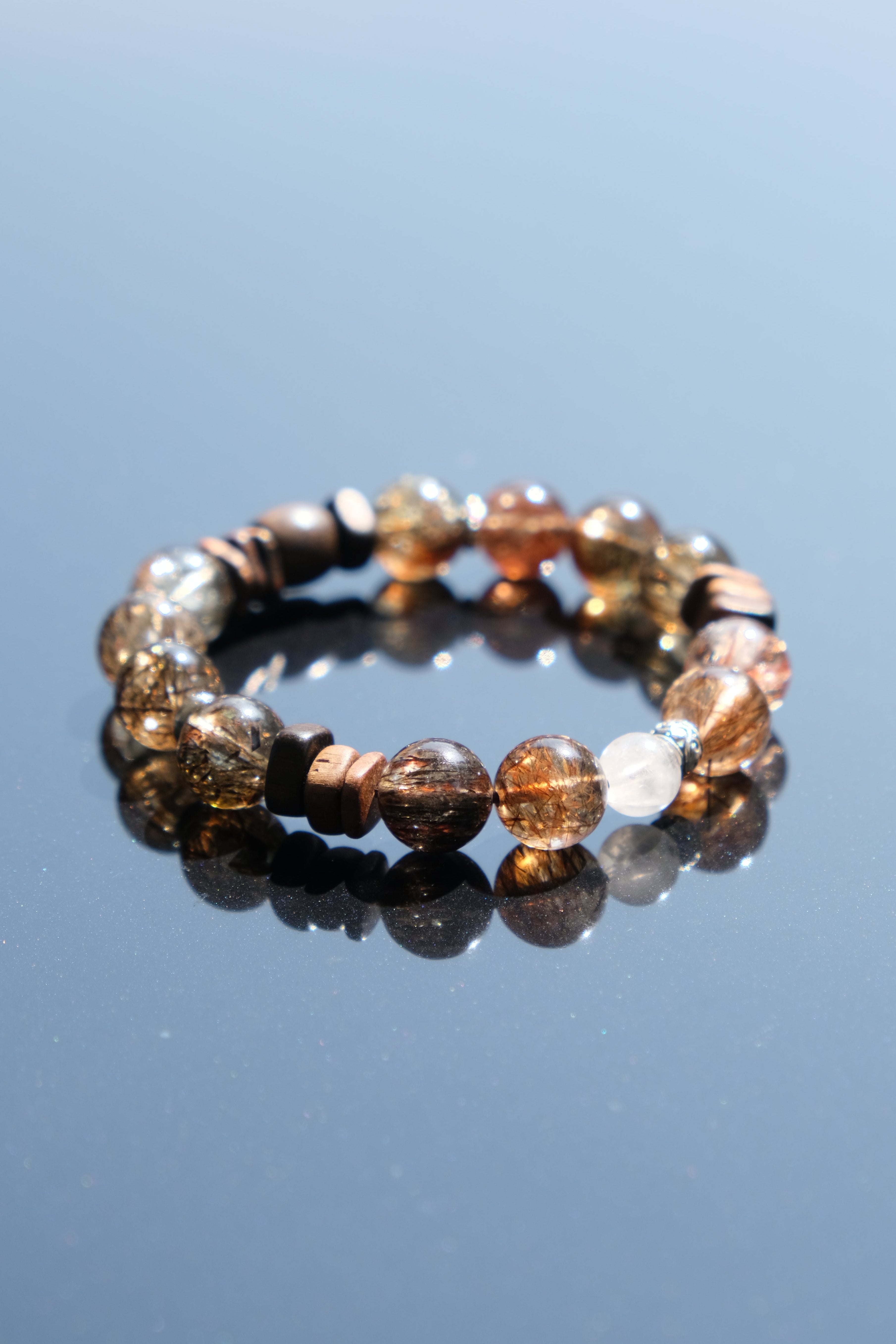 Beaded bracelet with multicolor stones on a clear blue background