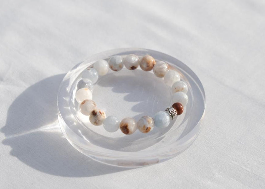 Beaded bracelet on a clear dish with a white background