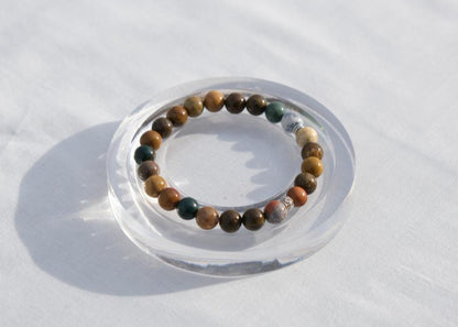 Beaded bracelet on a clear stand against a white background