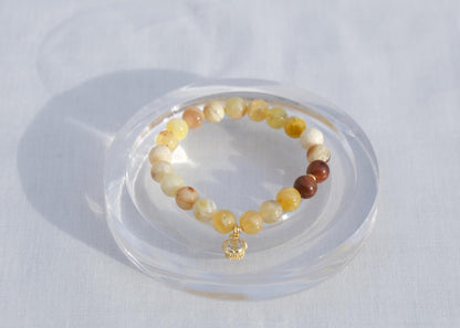 Multicolored beaded bracelet on a clear stand against a white background