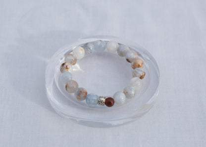 Beaded bracelet on a clear stand against a light gray background