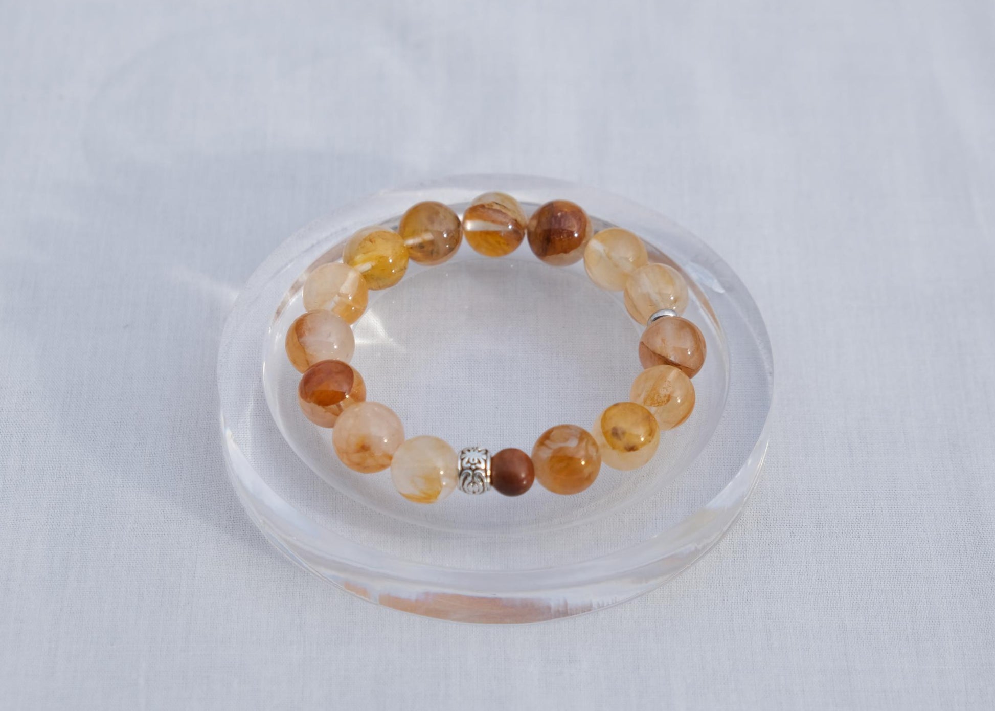 Beaded bracelet on a clear stand against a light gray background