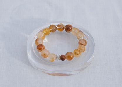 Beaded bracelet on a clear stand against a light gray background