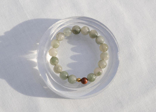 Beaded bracelet on a white surface with a clear circular stand